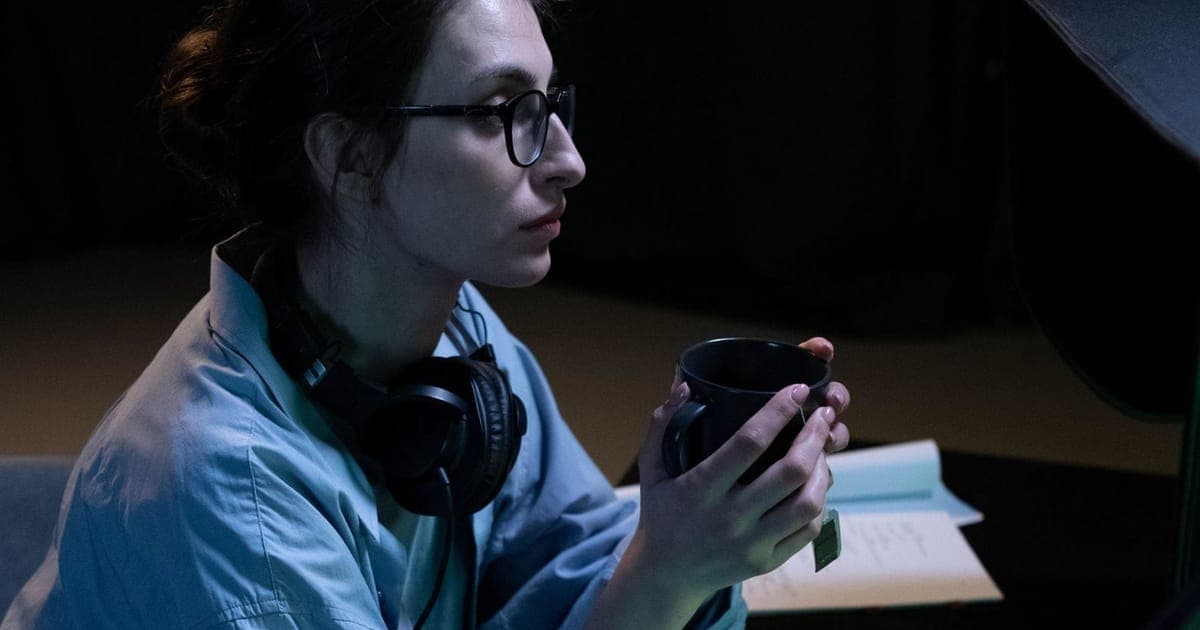 Analyst in headphones working late at a desk with printed reports